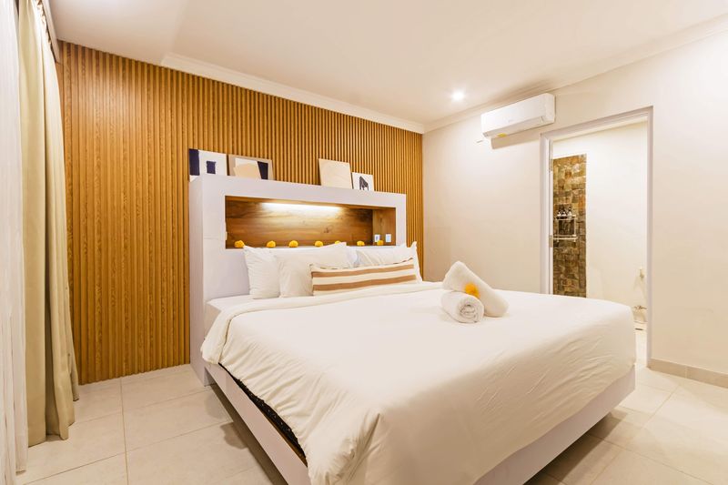 Bedroom with timber panelling and ensuite beyond